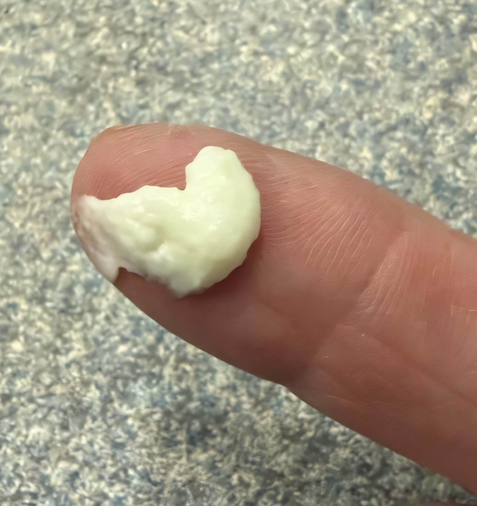 Close-up of cream texture swatch held on fingertip
