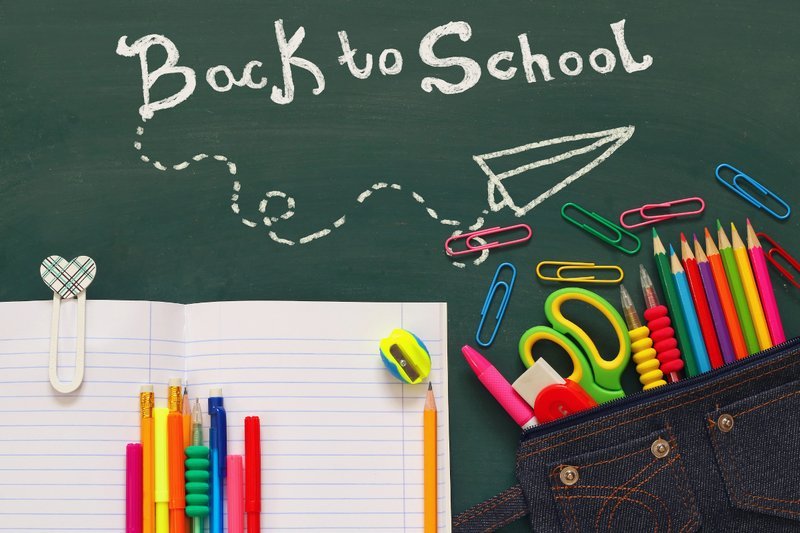 Back-to-school supplies and classroom items arranged on a desk