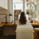 Woman working at a bright desk by a window, fall routine planning