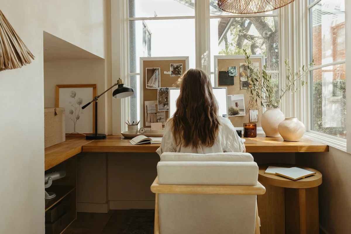 Woman working at a bright desk by a window, fall routine planning