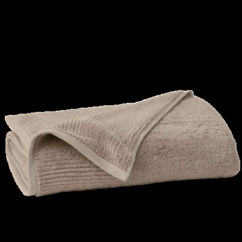 Folded beige terry cloth bath towel on a dark background
