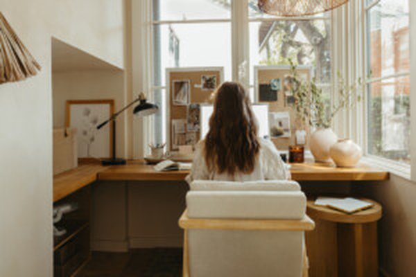 Woman sitting at a desk working on a laptop in a bright room